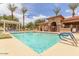 Community pool area with a clear blue pool, lounge chairs, and palm trees at 5436 W Chisum Trl, Phoenix, AZ 85083