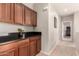 Functional hallway with dark cabinets, dark countertops, carpeted floors, and an entrance to other rooms at 5436 W Chisum Trl, Phoenix, AZ 85083