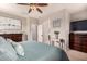 Inviting main bedroom features a ceiling fan, side tables, an upholstered headboard, and dresser at 5436 W Chisum Trl, Phoenix, AZ 85083