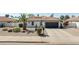 Front elevation showcasing desert landscaping, covered entryway, and two-car garage at 5719 E Paradise Ln, Scottsdale, AZ 85254
