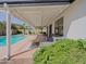 Cozy covered patio with comfortable seating, perfect for enjoying the view of the refreshing pool and green backyard at 5719 E Paradise Ln, Scottsdale, AZ 85254