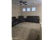 Spacious living room with three windows for natural light and a ceiling fan at 6629 W Polk St, Phoenix, AZ 85043