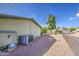 Back exterior featuring the AC unit, desert landscaping, and storage area at 67 S Amulet Ave, Mesa, AZ 85208