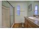 Well-lit bathroom features a glass-enclosed shower, vanity, and window for natural light at 67 S Amulet Ave, Mesa, AZ 85208