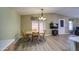 Open-concept dining room with vinyl floors, a hanging light, and backyard views at 67 S Amulet Ave, Mesa, AZ 85208