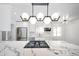 Bright kitchen featuring white cabinets, stainless appliances, a cooktop island, and modern light fixtures at 7041 E Cypress St St, Scottsdale, AZ 85257