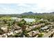 Aerial shot of a residential area with houses, a lake, mountains and golf course views in the background at 7500 E Mccormick Pkwy # 73, Scottsdale, AZ 85258