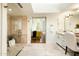 Well-lit bathroom leading to bedroom, with vanity and tiled shower at 7500 E Mccormick Pkwy # 73, Scottsdale, AZ 85258