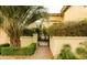Gated entrance with lush greenery, flowering bushes, and brick pathway at 7500 E Mccormick Pkwy # 73, Scottsdale, AZ 85258