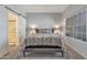 Bedroom with a sliding barn door to the bathroom, neutral décor, and a large window for natural light at 7675 E Mcdonald Dr # 107, Scottsdale, AZ 85250