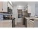 Well-lit kitchen featuring modern appliances, white cabinets, and stylish tile backsplash at 7675 E Mcdonald Dr # 107, Scottsdale, AZ 85250