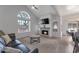 Bright living room with vaulted ceilings, modern fireplace, and a large window showcasing desert views at 7675 E Mcdonald Dr # 107, Scottsdale, AZ 85250