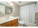 Bathroom featuring white shower curtain, round mirror, and natural wood cabinetry at 7827 E Parkview Dr, Mesa, AZ 85208