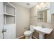 Compact bathroom featuring a pedestal sink, modern toilet, and built-in shelving for storage at 7827 E Parkview Dr, Mesa, AZ 85208