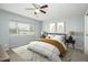 Staged bedroom featuring a ceiling fan, bed, neutral walls, and large window for ample natural light at 7827 E Parkview Dr, Mesa, AZ 85208