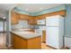 Cozy kitchen with wooden cabinets, white appliances, and a breakfast bar for casual dining at 7827 E Parkview Dr, Mesa, AZ 85208