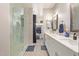 This primary bathroom boasts double sinks, ample counter space, and a walk-in closet with a marble-tiled shower at 8026 S 6Th Dr, Phoenix, AZ 85041