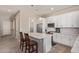 Modern kitchen featuring white cabinetry, stainless steel appliances, and a center island with seating at 8026 S 6Th Dr, Phoenix, AZ 85041
