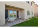 Outdoor patio area featuring white metal furniture, artificial turf, and a building exterior that is painted in neutral colors at 8026 S 6Th Dr, Phoenix, AZ 85041