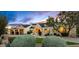 Charming single-story home featuring stone accents, manicured landscaping, and a three-car garage at 8220 E Sharon Dr, Scottsdale, AZ 85260