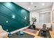 Bright home gym featuring an accent wall, exercise bike, bench, and workout space at 8220 E Sharon Dr, Scottsdale, AZ 85260