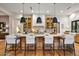 Bright kitchen with island, modern pendant lights, wooden cabinets, and hardwood flooring at 8220 E Sharon Dr, Scottsdale, AZ 85260