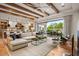 Open-concept living room featuring exposed beams, hardwood floors, and access to the outdoor patio at 8220 E Sharon Dr, Scottsdale, AZ 85260