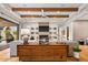 Stylish living room featuring wood beam ceilings, fireplace, modern shelving, and hardwood floors at 8220 E Sharon Dr, Scottsdale, AZ 85260