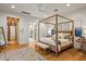 Serene bedroom featuring a four-poster bed, hardwood floors, and an ensuite bathroom at 8220 E Sharon Dr, Scottsdale, AZ 85260
