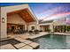 Expansive backyard pool with travertine tile and seamless indoor-outdoor living space at 8220 E Sharon Dr, Scottsdale, AZ 85260