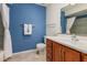 This is a well lit bathroom with blue walls, tile floors and a wood vanity at 9816 N 95Th Dr # A, Peoria, AZ 85345