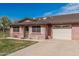 Charming brick home featuring an attached garage, covered patio, and manicured lawn at 9816 N 95Th Dr # A, Peoria, AZ 85345