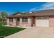 Inviting single-level home with a brick facade, attached garage, and a cozy seating area on the front patio at 9816 N 95Th Dr # A, Peoria, AZ 85345