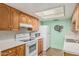 Bright kitchen with white appliances, wood cabinets, and stainless-steel sink at 9816 N 95Th Dr # A, Peoria, AZ 85345