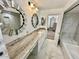 Elegant bathroom with double vanity, marble countertops, decorative mirrors, and tub-shower combo at 10113 E Topaz Dr, Scottsdale, AZ 85258