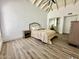 Cozy bedroom with vaulted ceiling, wood floors, neutral walls, and a mirrored closet at 10113 E Topaz Dr, Scottsdale, AZ 85258