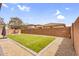 Backyard with synthetic grass bordered by decorative stone and a stucco wall for privacy at 10425 E Corbin Ave, Mesa, AZ 85212
