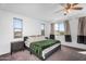 The primary bedroom offers a ceiling fan and ample natural light from two windows at 10425 E Corbin Ave, Mesa, AZ 85212