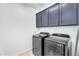 Laundry room with modern washer and dryer, and ample cabinet space at 10425 E Corbin Ave, Mesa, AZ 85212