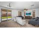 Cozy living room featuring plush seating, a ceiling fan, and a sliding glass door with access to the backyard at 10425 E Corbin Ave, Mesa, AZ 85212
