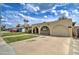 A single-story home showcases an arched carport and a well-manicured lawn under a bright, cloudy sky at 1059 E 9Th Ave, Mesa, AZ 85204