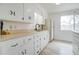Bright kitchen with classic white cabinetry, vintage hardware, and a window offering natural light at 1059 E 9Th Ave, Mesa, AZ 85204