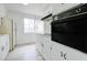 A well lit kitchen featuring ample white cabinets and modern appliances, with natural light flooding in from a window at 1059 E 9Th Ave, Mesa, AZ 85204
