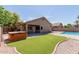 Secluded backyard featuring a hot tub, artificial grass, covered patio, and pool at 1072 E Jade Dr, Chandler, AZ 85286