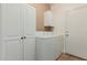 Bright laundry area with white washer, dryer, and cabinets for ample storage and organization at 1072 E Jade Dr, Chandler, AZ 85286