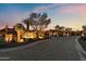Elegant community entrance with stone signage, mature trees and lighting at 10799 E Florence Way, Scottsdale, AZ 85262