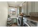 Well-equipped laundry room featuring modern appliances, custom cabinetry, and a decorative tile floor at 10799 E Florence Way, Scottsdale, AZ 85262