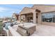 An outdoor grill and entertaining area overlooking the pool and patio with covered seating at 10799 E Florence Way, Scottsdale, AZ 85262