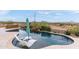 Stunning pool featuring sun loungers, a built-in bar, rock waterfall and desert landscape at 10799 E Florence Way, Scottsdale, AZ 85262