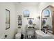 Charming powder room with unique decor, stylish fixtures, and abundant natural light from arched window at 10799 E Florence Way, Scottsdale, AZ 85262